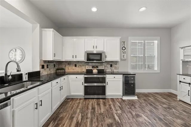 a large kitchen with stainless steel appliances granite countertop a stove a sink and a granite counter tops