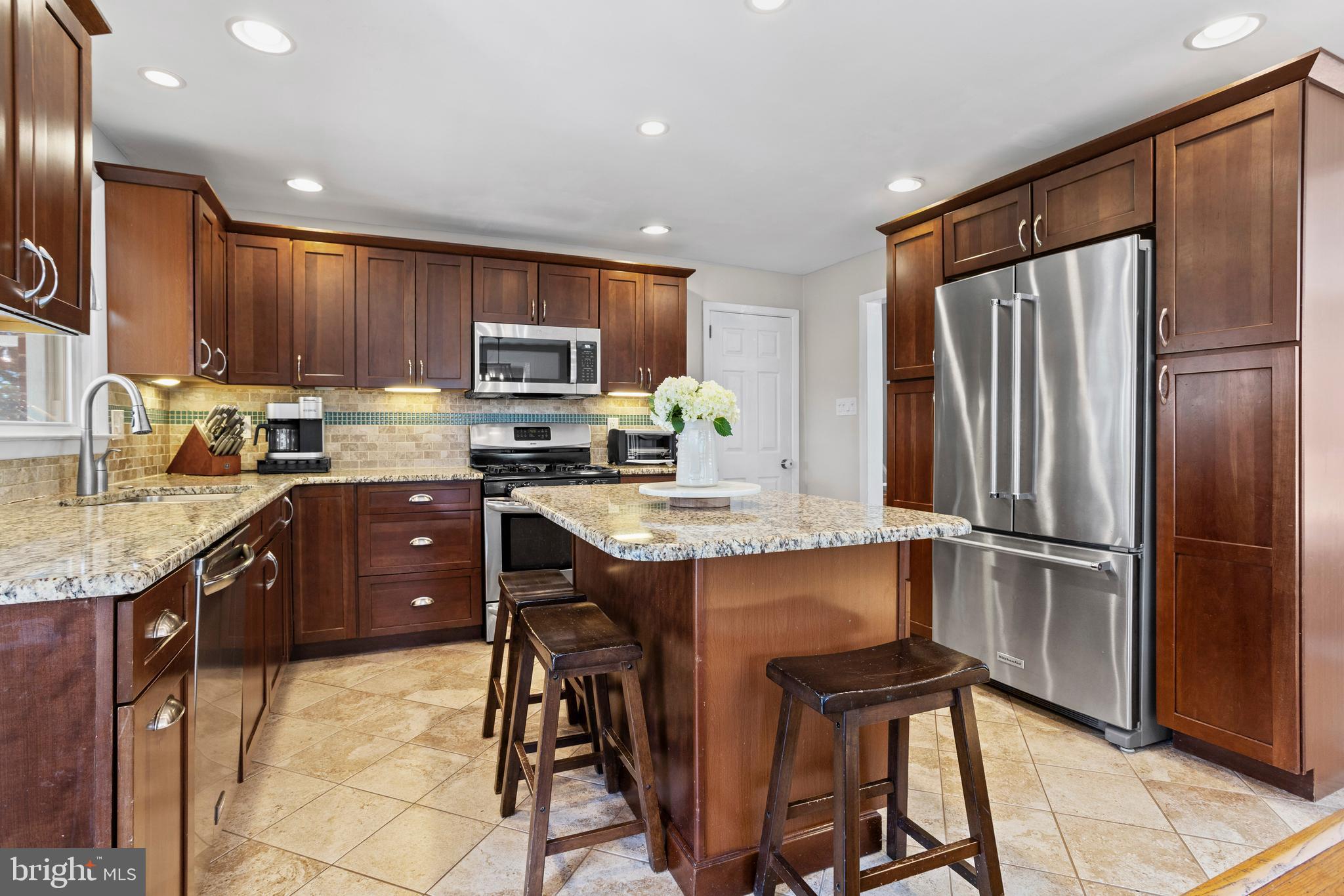 105 Longview Drive Springfield, PA 19064 - Photo 11 of 33 a kitchen with stainless steel appliances granite countertop a refrigerator stove microwave and sink