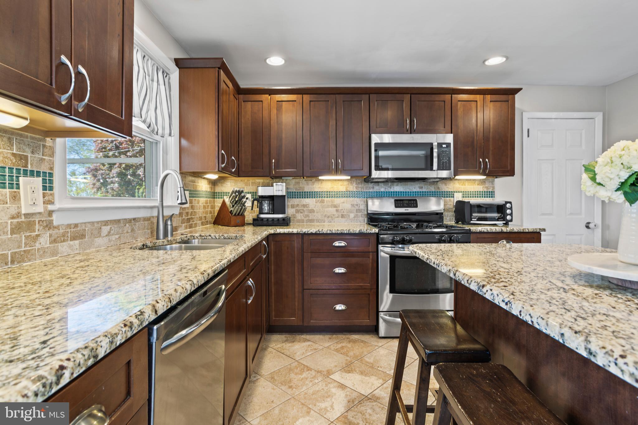 105 Longview Drive Springfield, PA 19064 - Photo 12 of 33 a kitchen with stainless steel appliances granite countertop a stove sink and cabinets