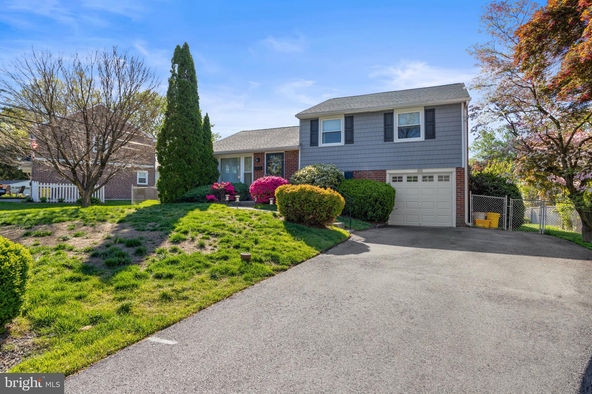 105 Longview Drive Springfield, PA 19064 - Photo 2 of 33 a front view of a house with a yard and garage