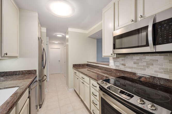 111 East Chestnut Street, Unit 22H Chicago, IL 60611 - Photo 12 of 27 a kitchen with stainless steel appliances a sink a stove and cabinets