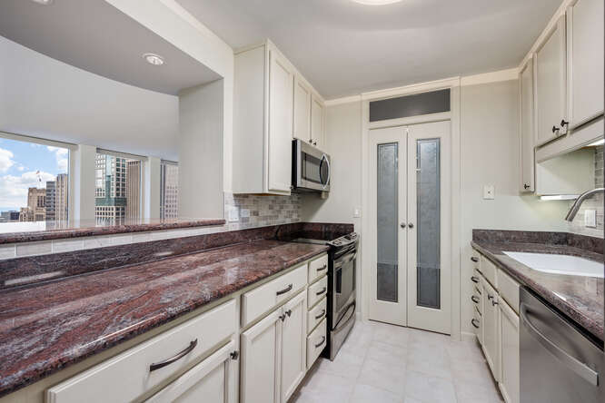 111 East Chestnut Street, Unit 22H Chicago, IL 60611 - Photo 13 of 27 a kitchen with granite countertop a sink stainless steel appliances and cabinets
