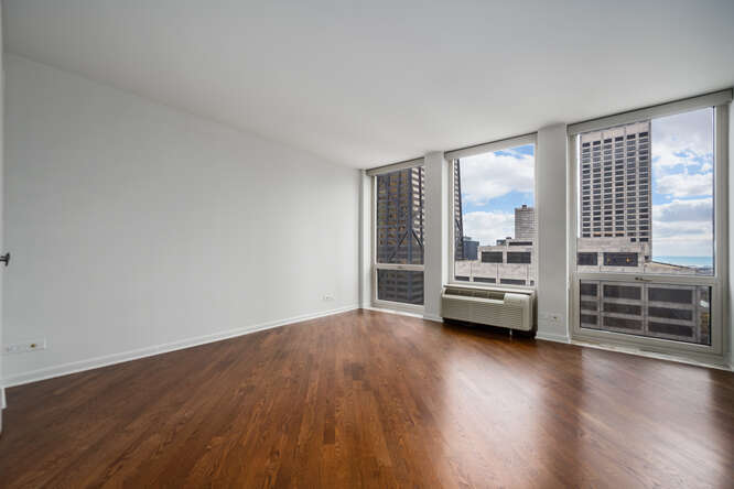 111 East Chestnut Street, Unit 22H Chicago, IL 60611 - Photo 15 of 27 wooden floor and windows in an empty room with a window