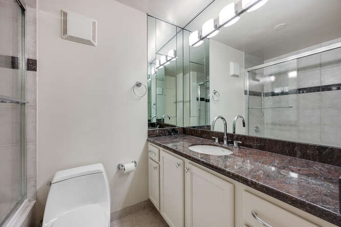 111 East Chestnut Street, Unit 22H Chicago, IL 60611 - Photo 16 of 27 a bathroom with a granite countertop sink and a mirror