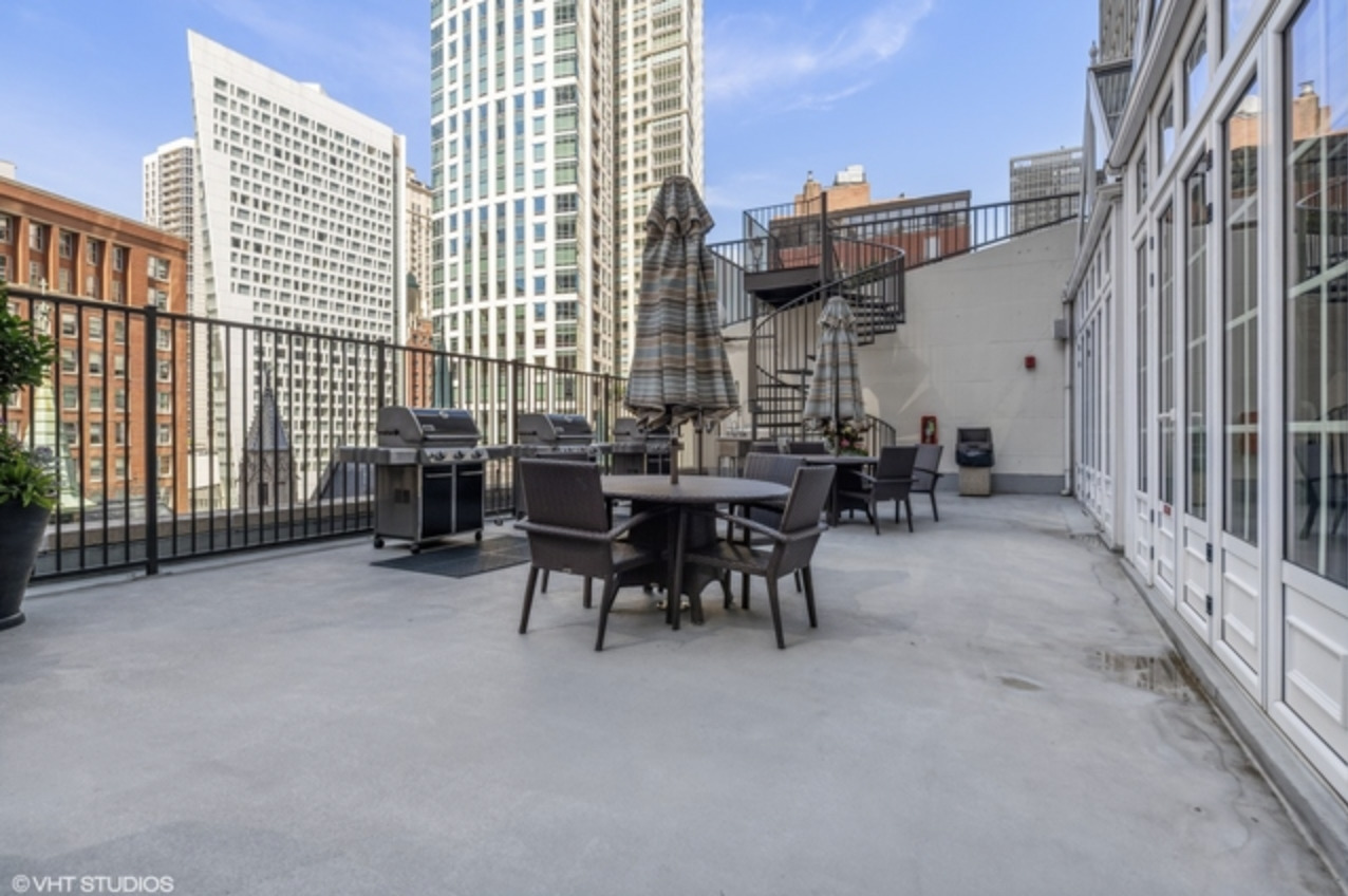 111 East Chestnut Street, Unit 22H Chicago, IL 60611 - Photo 25 of 27 a view of a patio with a table and chairs