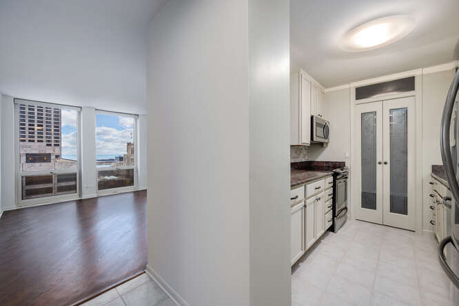 111 East Chestnut Street, Unit 22H Chicago, IL 60611 - Photo 3 of 27 a view of a kitchen with refrigerator stove and wooden floor