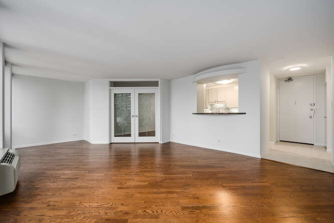 111 East Chestnut Street, Unit 22H Chicago, IL 60611 - Photo 5 of 27 a view of an empty room with wooden floor and a window