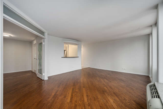 111 East Chestnut Street, Unit 22H Chicago, IL 60611 - Photo 8 of 27 an empty room with wooden floor and windows