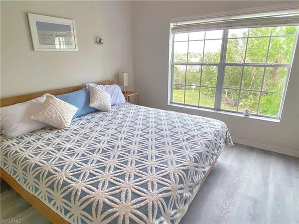 a bedroom with a bed and a flat tv screen on the dresser