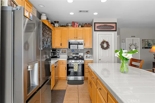 a kitchen with stainless steel appliances granite countertop a refrigerator a stove and a sink
