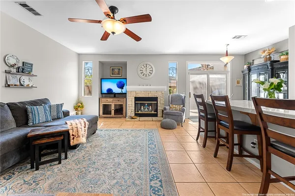 a living room with furniture a fireplace and a flat screen tv