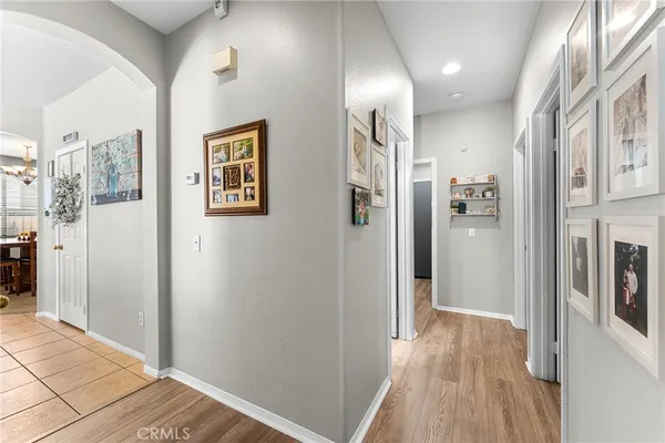 a view of a hallway with wooden floor and living room