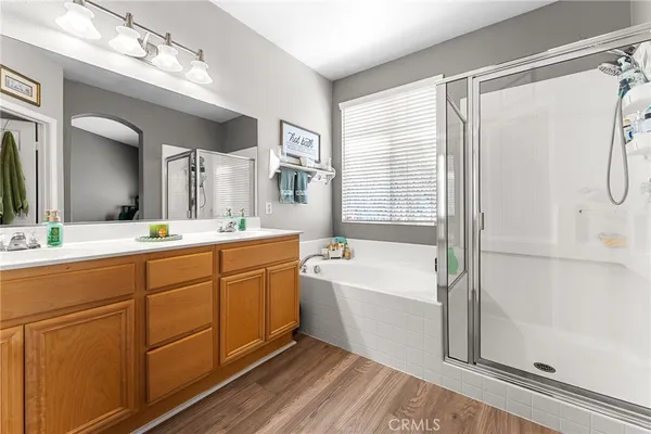 a spacious bathroom with a double vanity sink a mirror a bathtub and next to a window