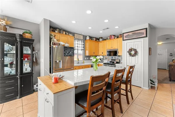 a kitchen with a dining table chairs and refrigerator