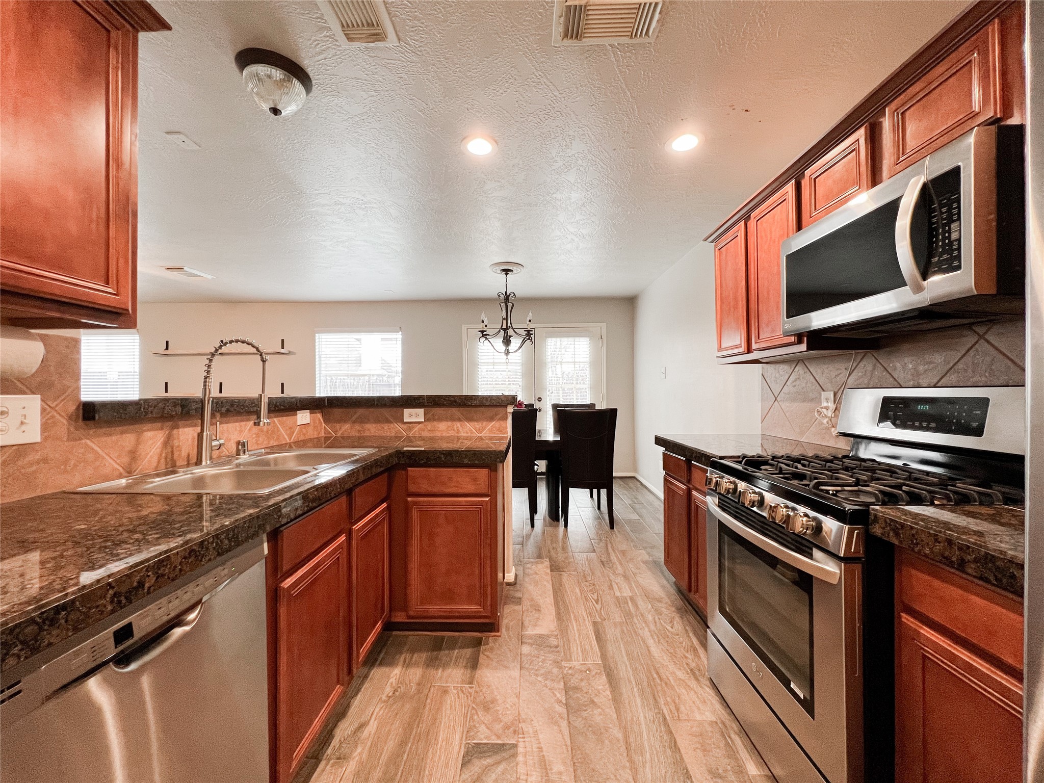 10838 Waterfern Court Houston, TX 77064 - Photo 16 of 28 Fully equipped kitchen with stainless steel appliances, granite countertops, and ample storage space—ideal for cooking and entertaining in style.