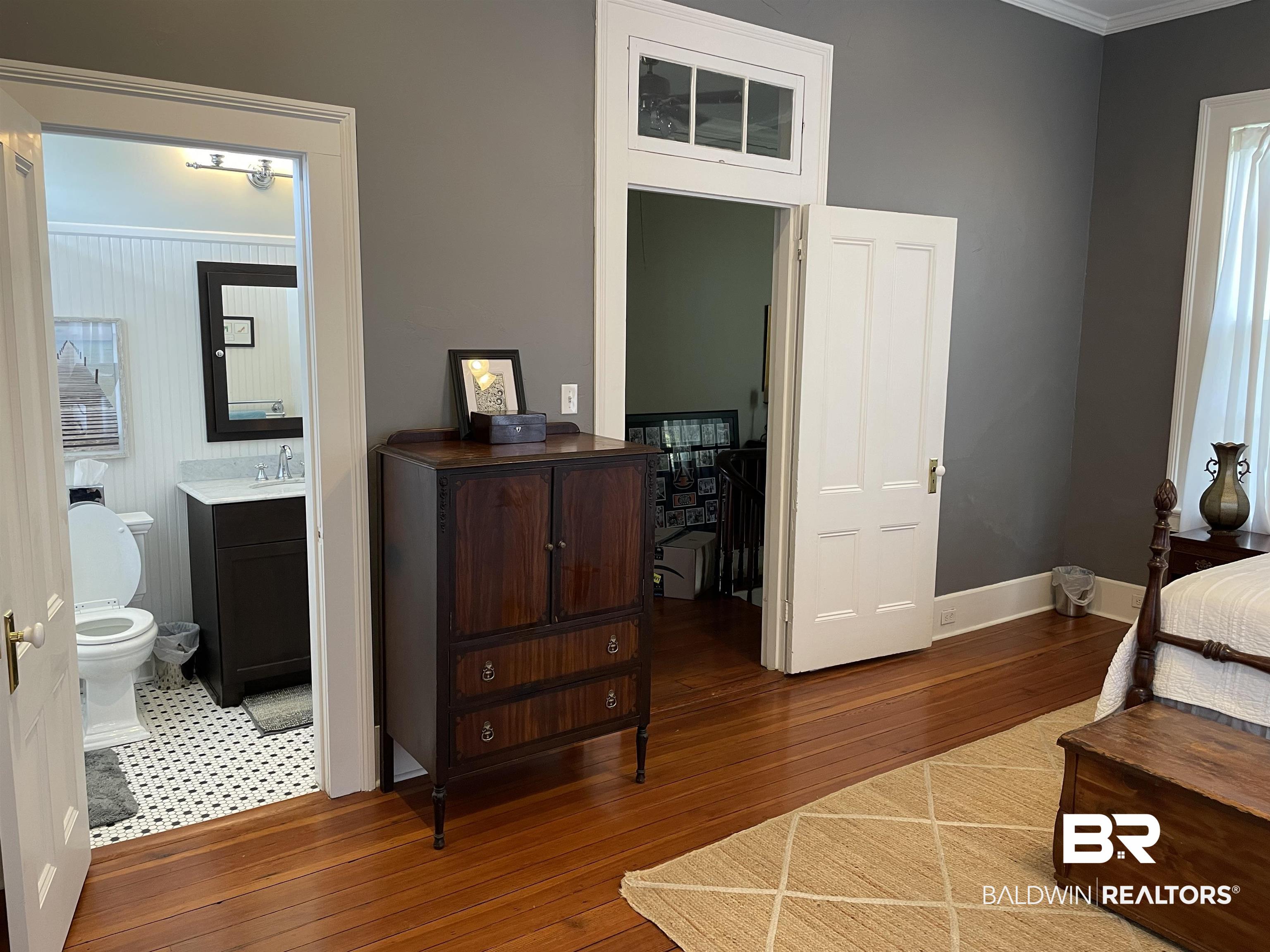 1001 Augusta Street Mobile, AL 36604 - Photo 11 of 26 Bedroom featuring sink, crown molding, wood-type flooring, and ensuite bath