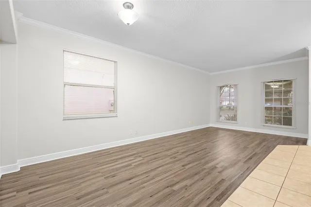 a view of empty room with wooden floor