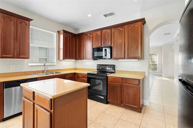a kitchen with stainless steel appliances granite countertop a refrigerator stove and sink