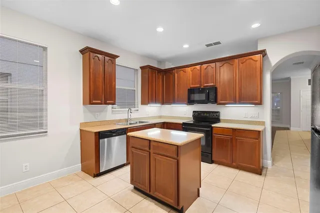 a kitchen with a refrigerator sink and cabinets
