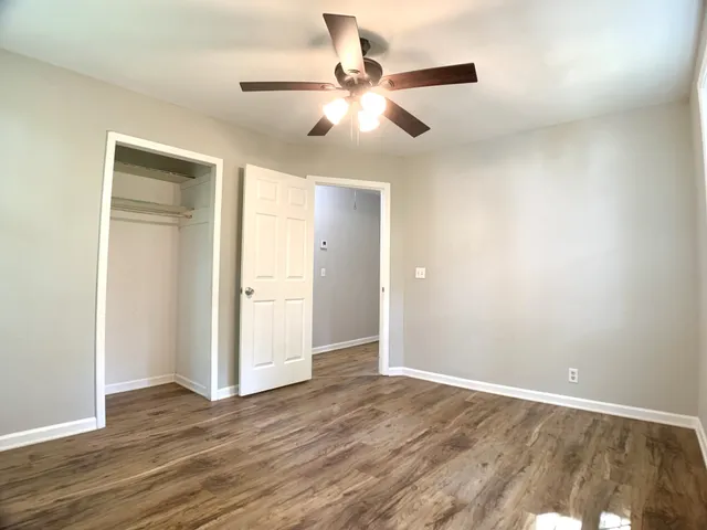 an empty room with wooden floor and windows