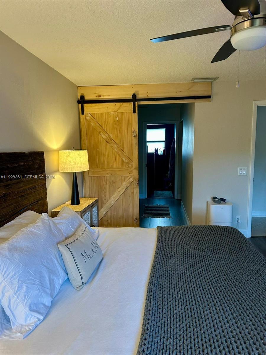 2089 Augusta Weston, FL 33326 - Photo 30 of 30 a bedroom with a bed and a lamp on dresser