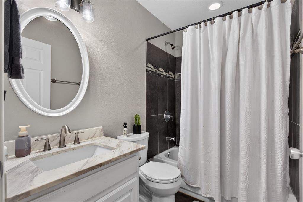 100 Radecke Road Krum, TX 76249 - Photo 20 of 29 Bathroom vanity featuring a rectangular undermount sink, dual-handle faucet, and patterned countertop