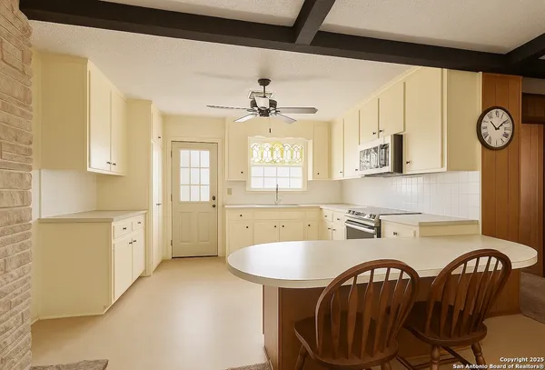 a kitchen with dining table chairs a sink and a stove