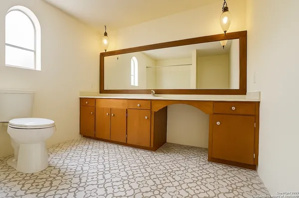 a bathroom with a sink a toilet and mirror