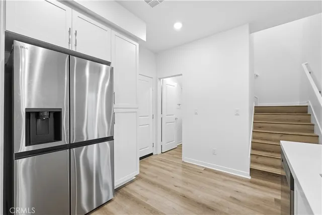 a view of a kitchen with wooden floor and staircase