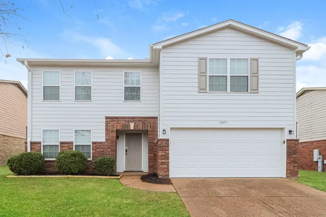 a view of a house with brick walls and a yard