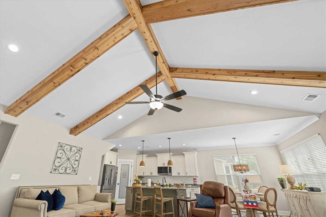 6834 Midway Road Pelzer, SC 29669 - Photo 16 of 50 This living space features vaulted ceilings and exposed wooden beams, creating an airy and natural ambiance.