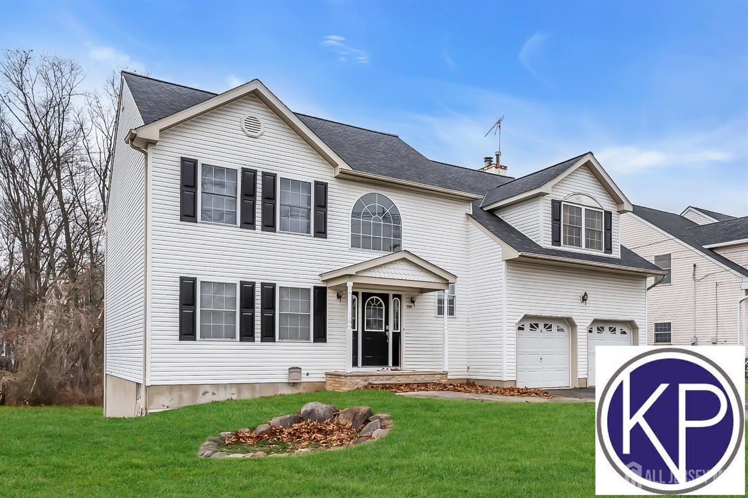 a front view of a house with a garden and yard