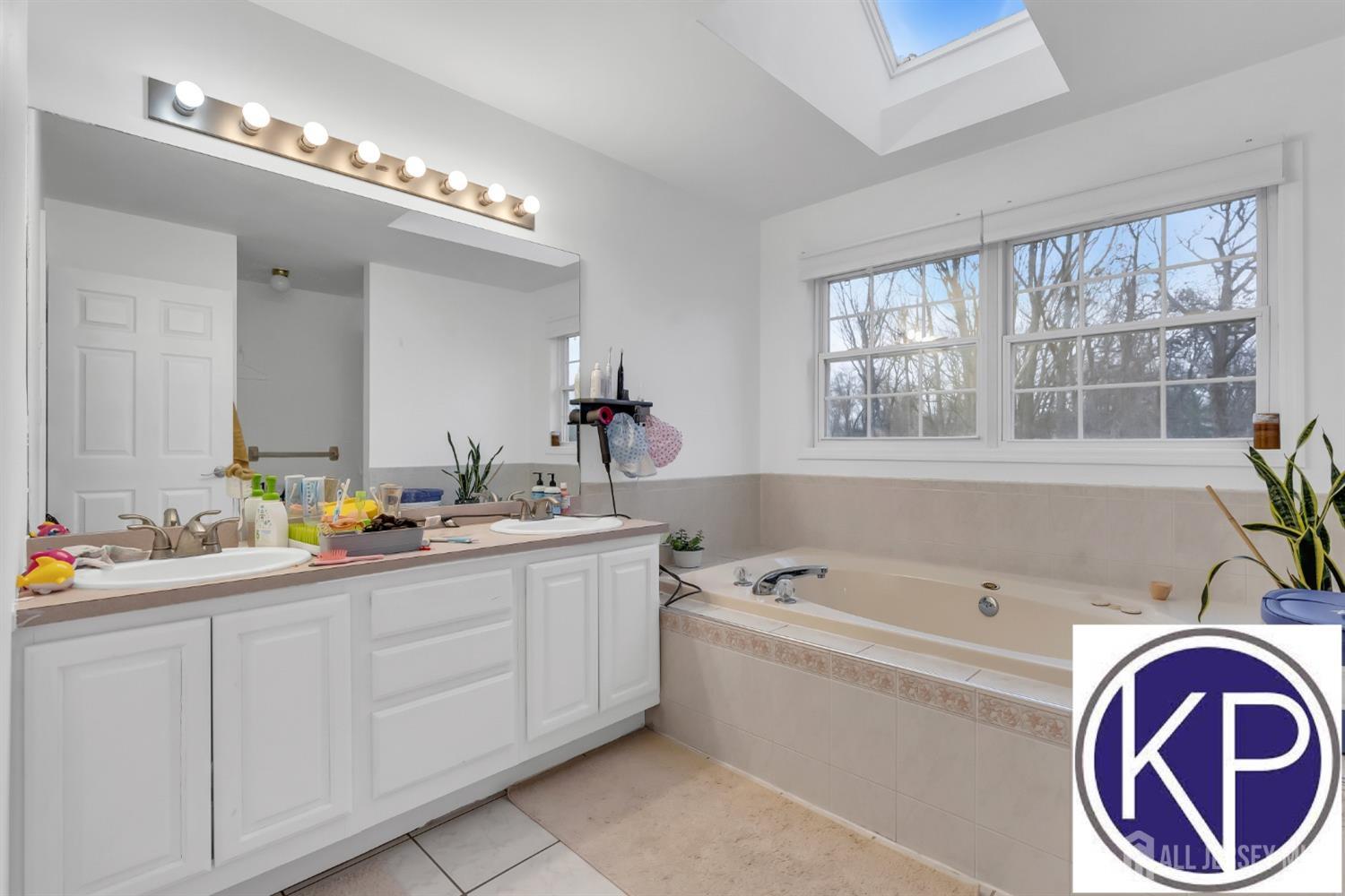 109 Jordan Road Colonia, NJ 07067 - Photo 20 of 30 a bathroom with a bathtub a double vanity sink and a window