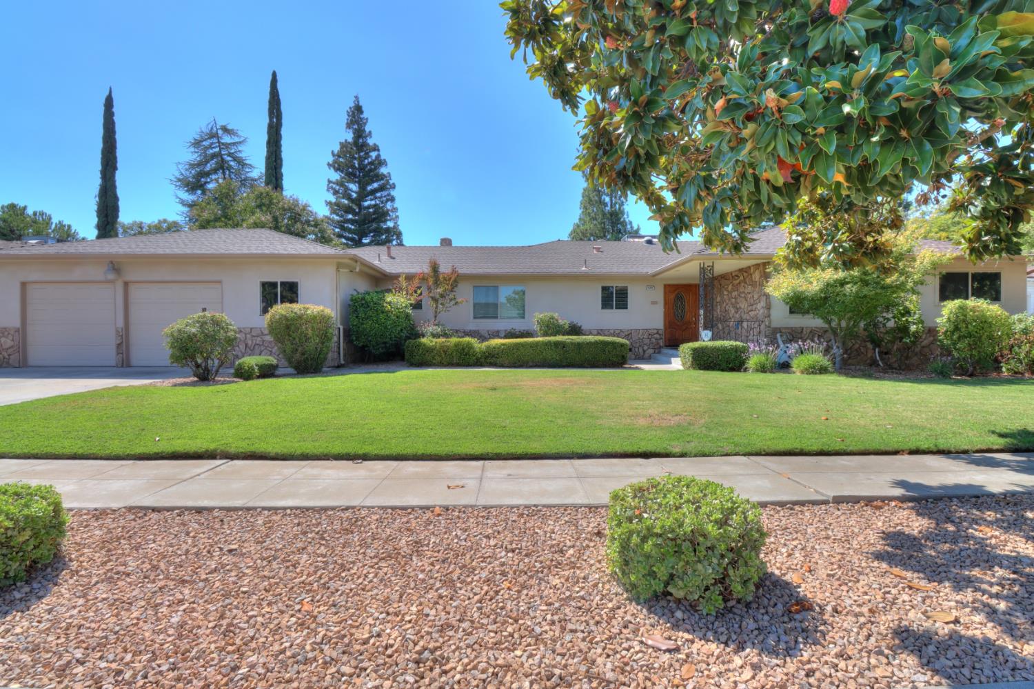 6265 North Colonial Avenue Fresno, CA 93704 - Photo 1 of 22 a front view of a house with a yard and garage