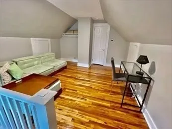 a living room with couch and a wooden floor