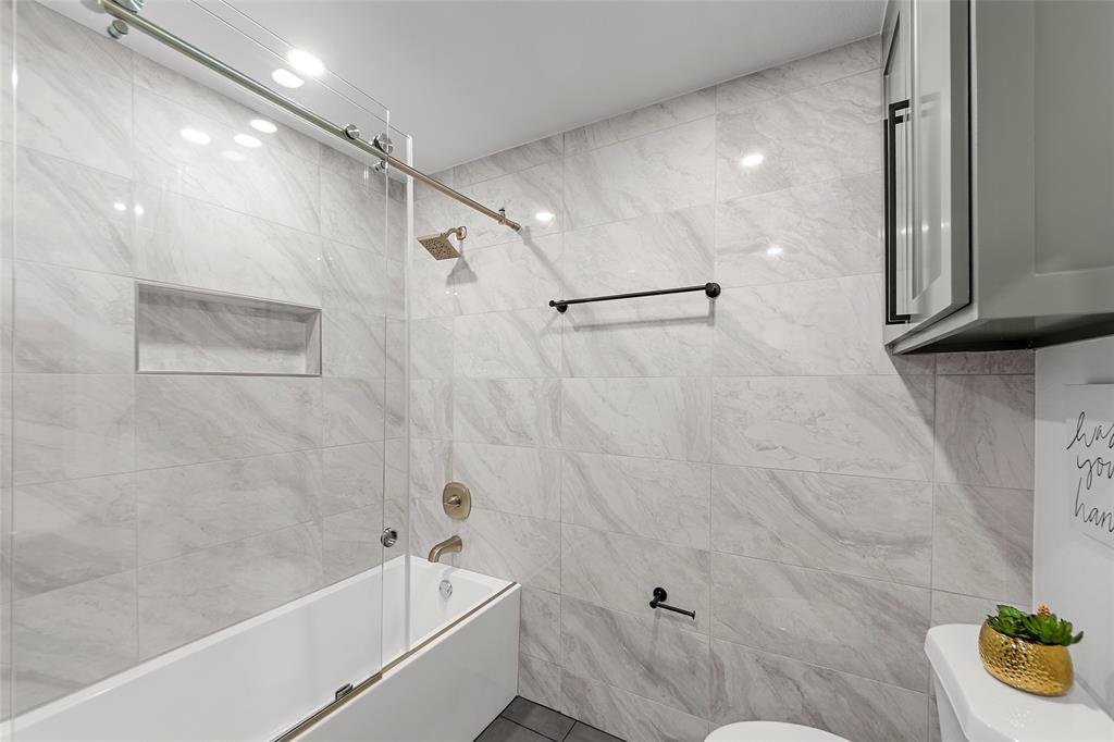 2945 Healey Drive Dallas, TX 75228 - Photo 16 of 38 a bathroom with a tub and a shower