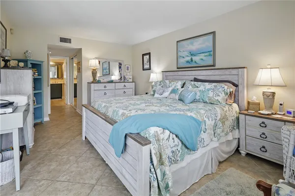 a spacious bedroom with a bed and wooden floor