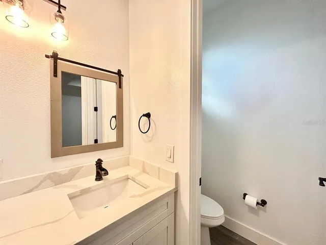 a bathroom with a sink a toilet and a mirror