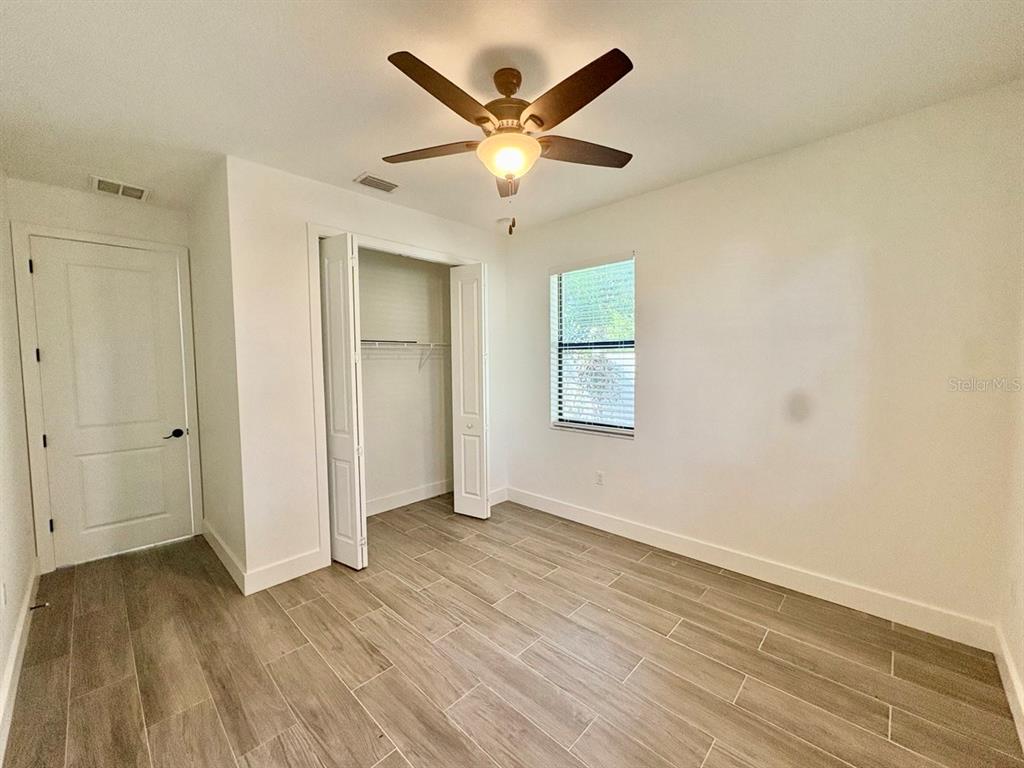 3228 West Beach Street Tampa, FL 33607 - Photo 15 of 22 an empty room with wooden floor and ceiling fan