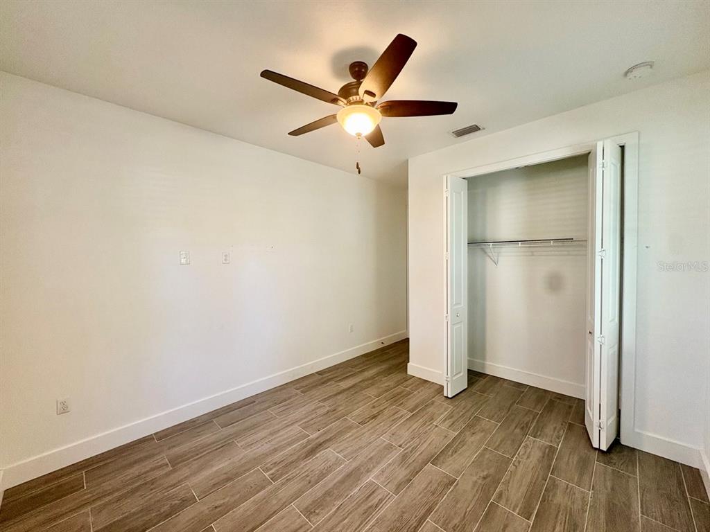 3228 West Beach Street Tampa, FL 33607 - Photo 16 of 22 an empty room with wooden floor and a ceiling fan