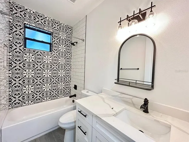 a bathroom with a sink a toilet and a mirror