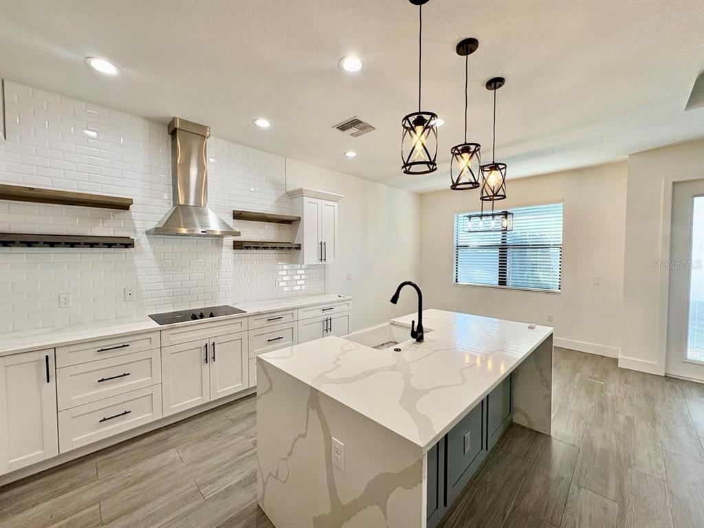 3228 West Beach Street Tampa, FL 33607 - Photo 8 of 22 a kitchen with a sink chandelier and wooden floor