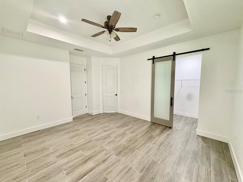 3228 West Beach Street Tampa, FL 33607 - Photo 10 of 22 an empty room with wooden floor and a ceiling fan