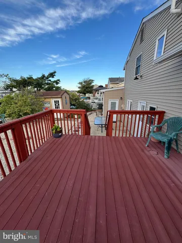 a balcony with wooden floor table and chairs