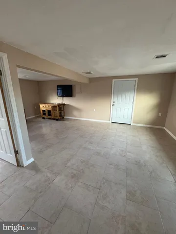 an empty room with fire place and windows