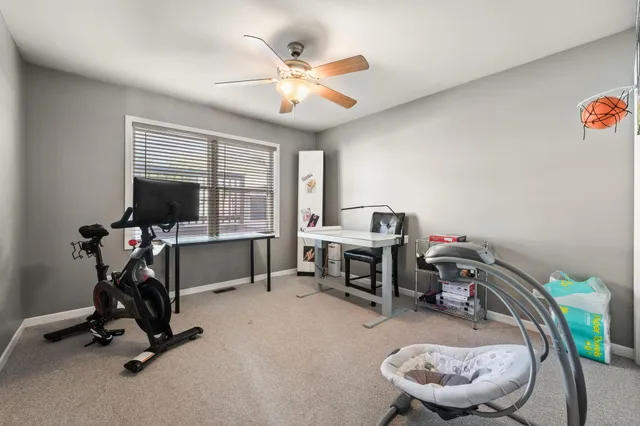 a view of a workspace with furniture and a window