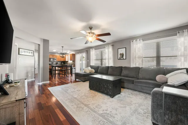 a living room with furniture kitchen view and a large window