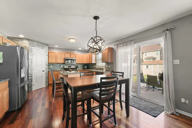 a dining room filled with furniture a chandelier and wooden floor