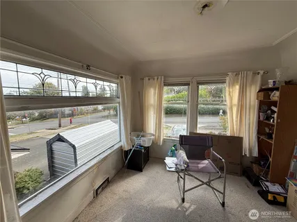 a living room with furniture a flat screen tv and a floor to ceiling window