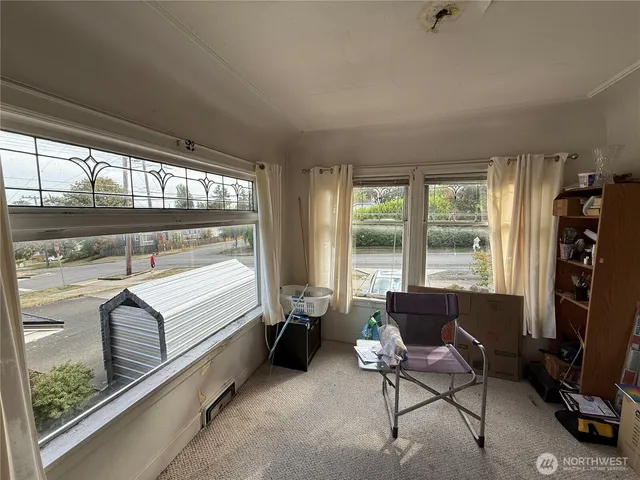 a living room with furniture a flat screen tv and a floor to ceiling window